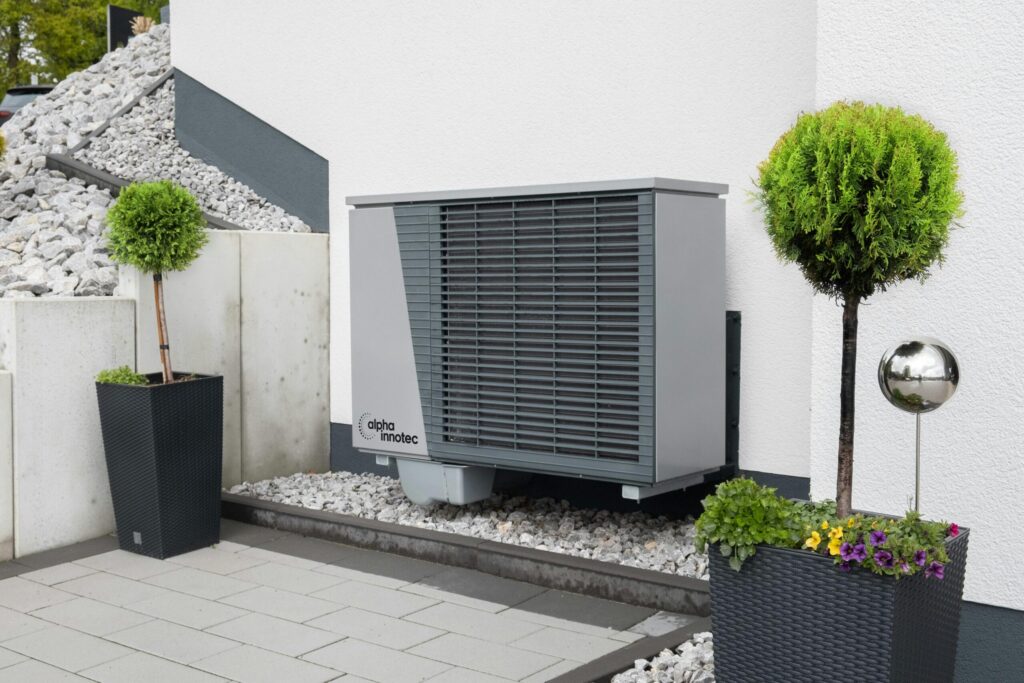 Modern air conditioning unit with flower pots and sleek decor outdoors.